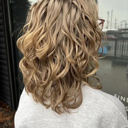 Client with soft blonde balayage waves styled at Curls Done Wright