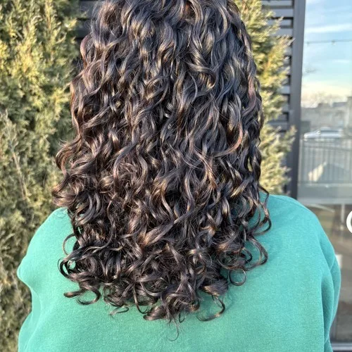 Client with defined dark brown spiral curls after a visit to Curls Done Wright
