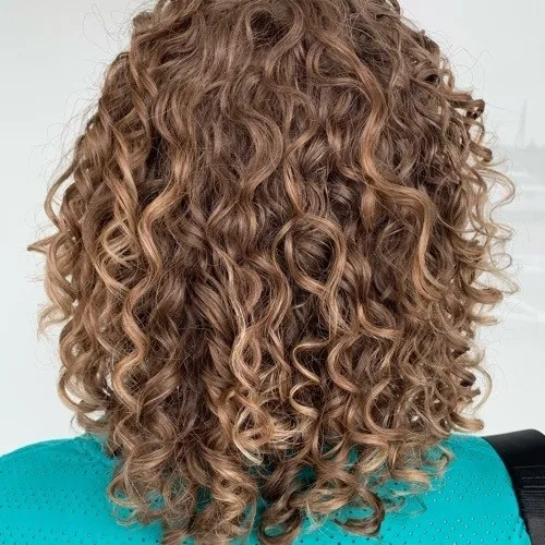 Client with honey blonde ringlets shaped by Curls Done Wright