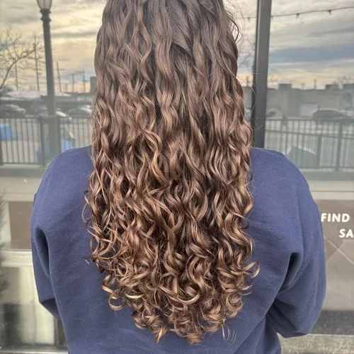 Client with long caramel curls after a dry cut at Curls Done Wright